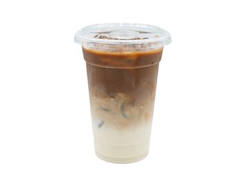 Iced coffee with milk in a clear plastic cup with a lid.