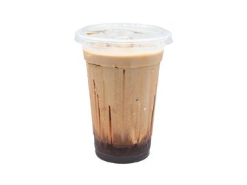 Iced coffee with syrup in a clear plastic cup and lid.