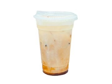 Iced milk tea in a clear plastic cup with a sealed lid.