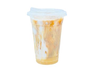Iced caramel macchiato in a clear plastic cup with a lid.