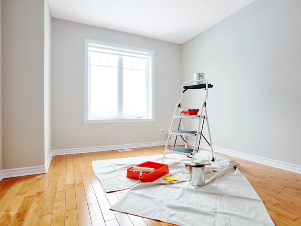 A room with a ladder and wall paint and tools