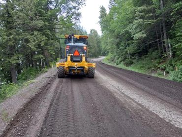 Utilizing a road grader and an excavator to achieve the results of a finished grade road. 