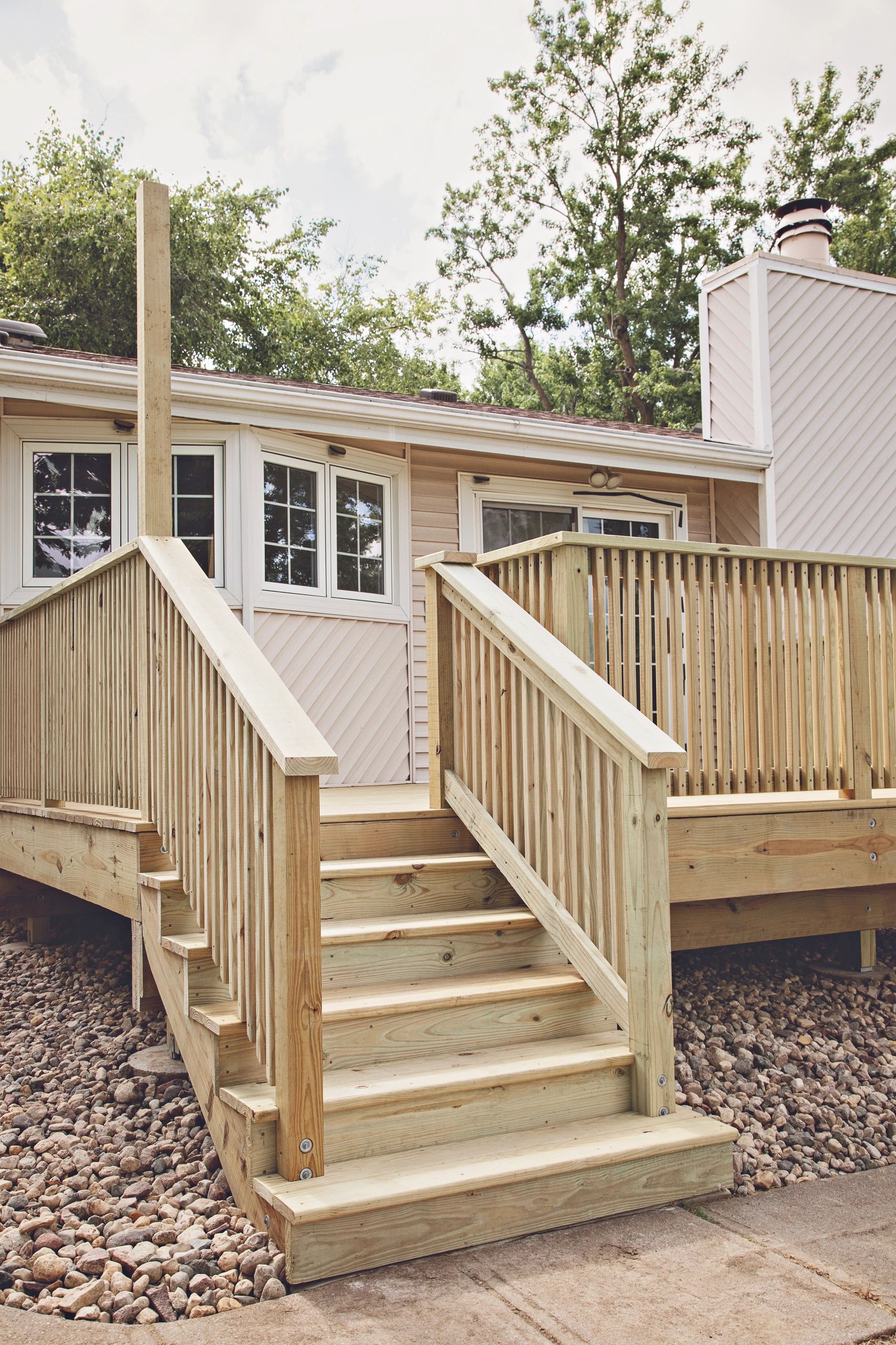 New wooden deck and stairs attached to a house.