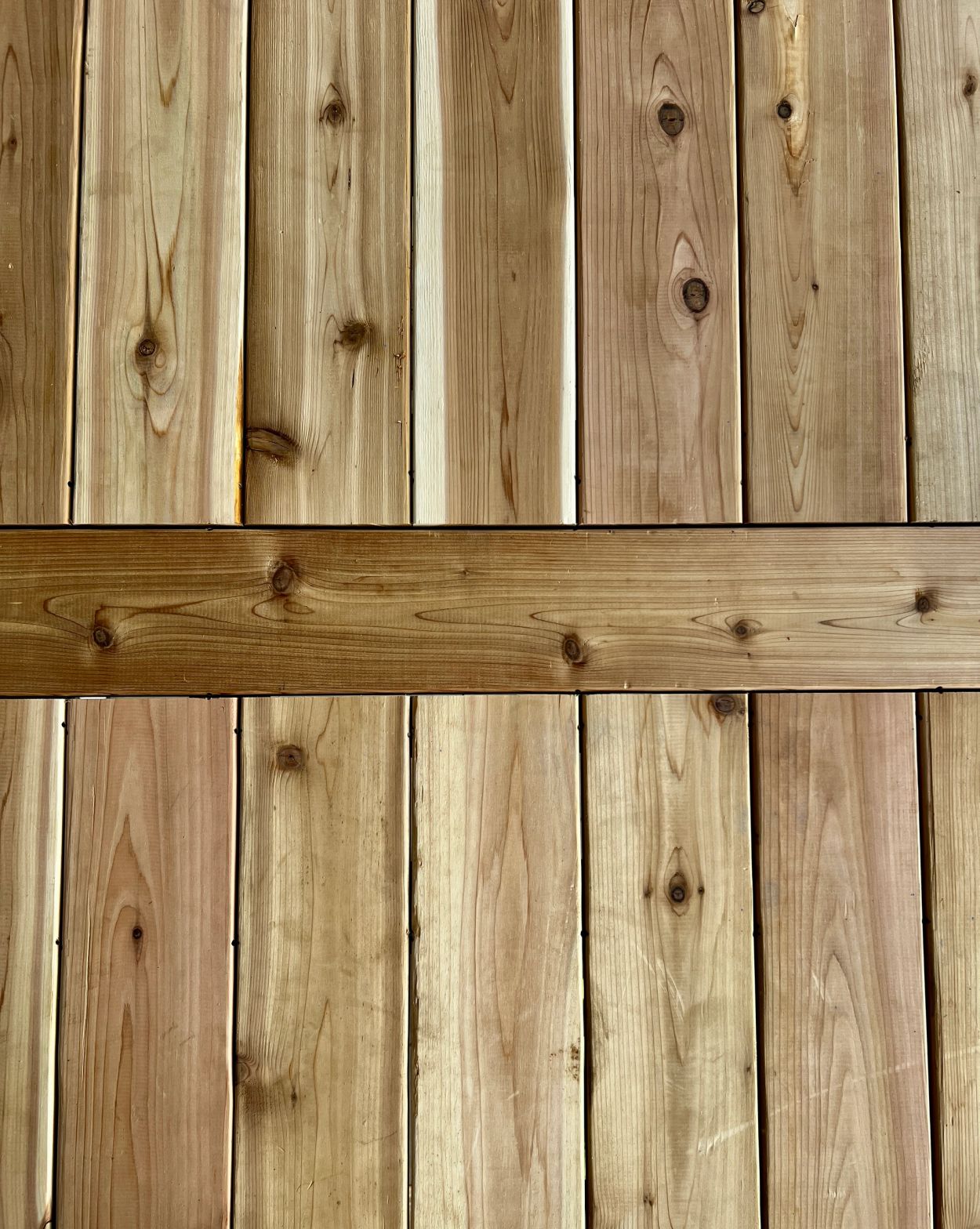 Close-up of wooden planks with horizontal support beam.