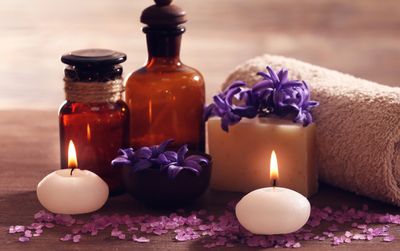 A calming spa setup with candles, flowers, and essential oils.