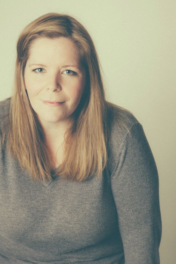 Portrait of a woman with long blonde hair in a gray sweater.