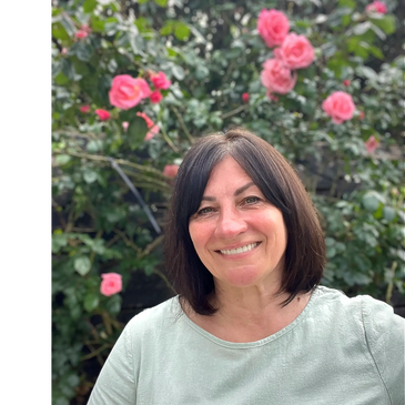 "Smiling woman standing among blooming roses, — a moment of connection with nature