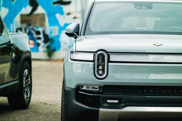 Front view of the new Rivian SUV with graffiti in the background.