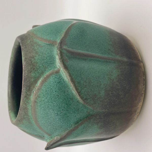 Green ceramic vase with leaf-like patterns and textured surface.