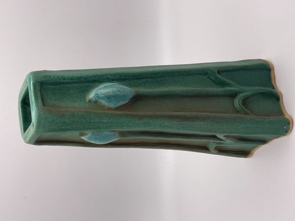 Green ceramic vase with embossed leaf designs and a square opening.