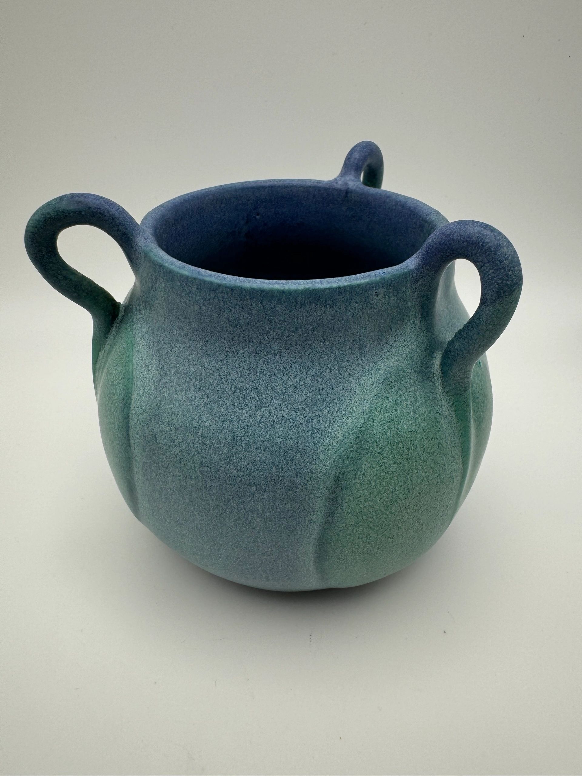Blue pottery vase with three handles.