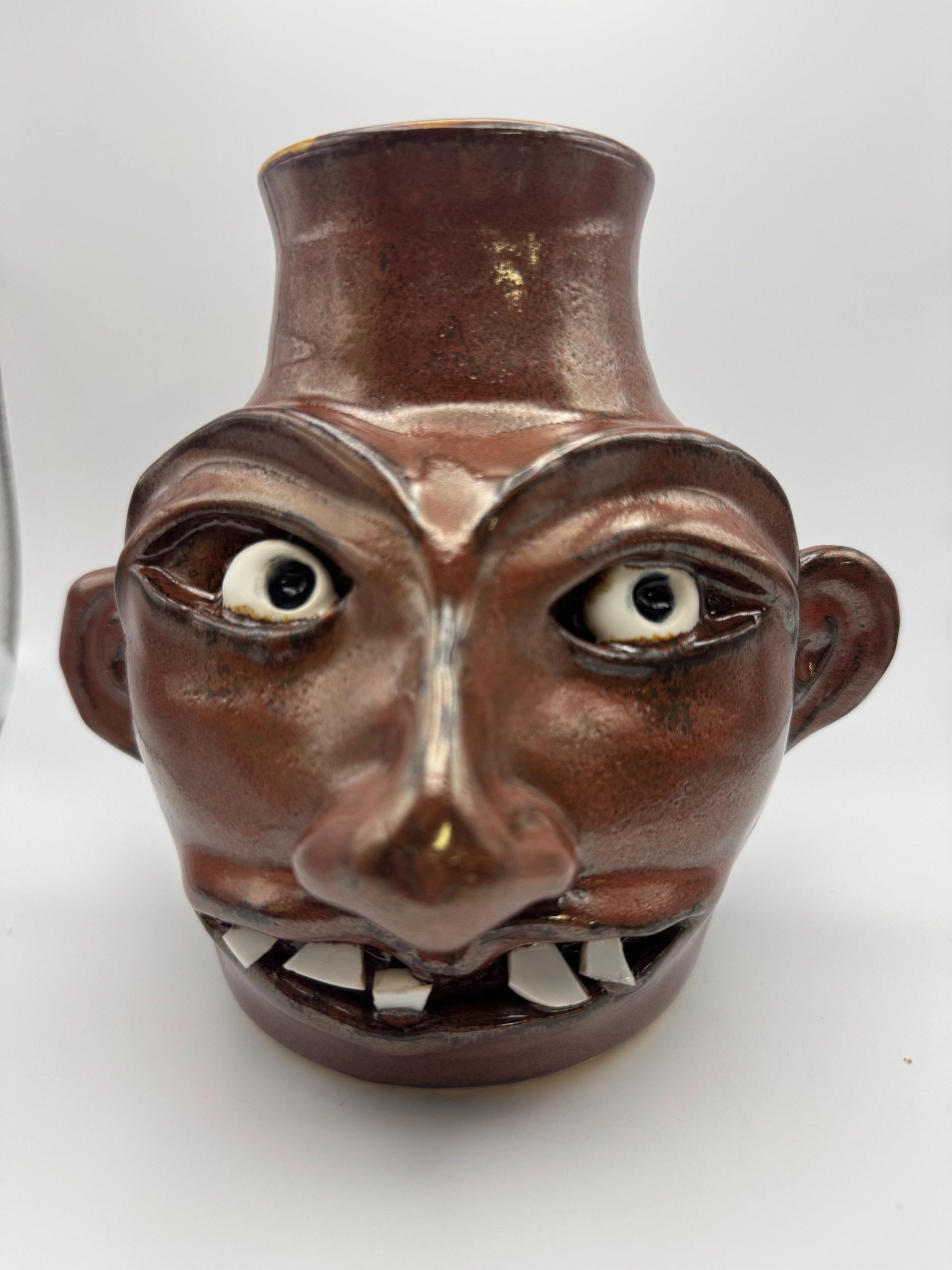 Ceramic face mug with exaggerated features.
