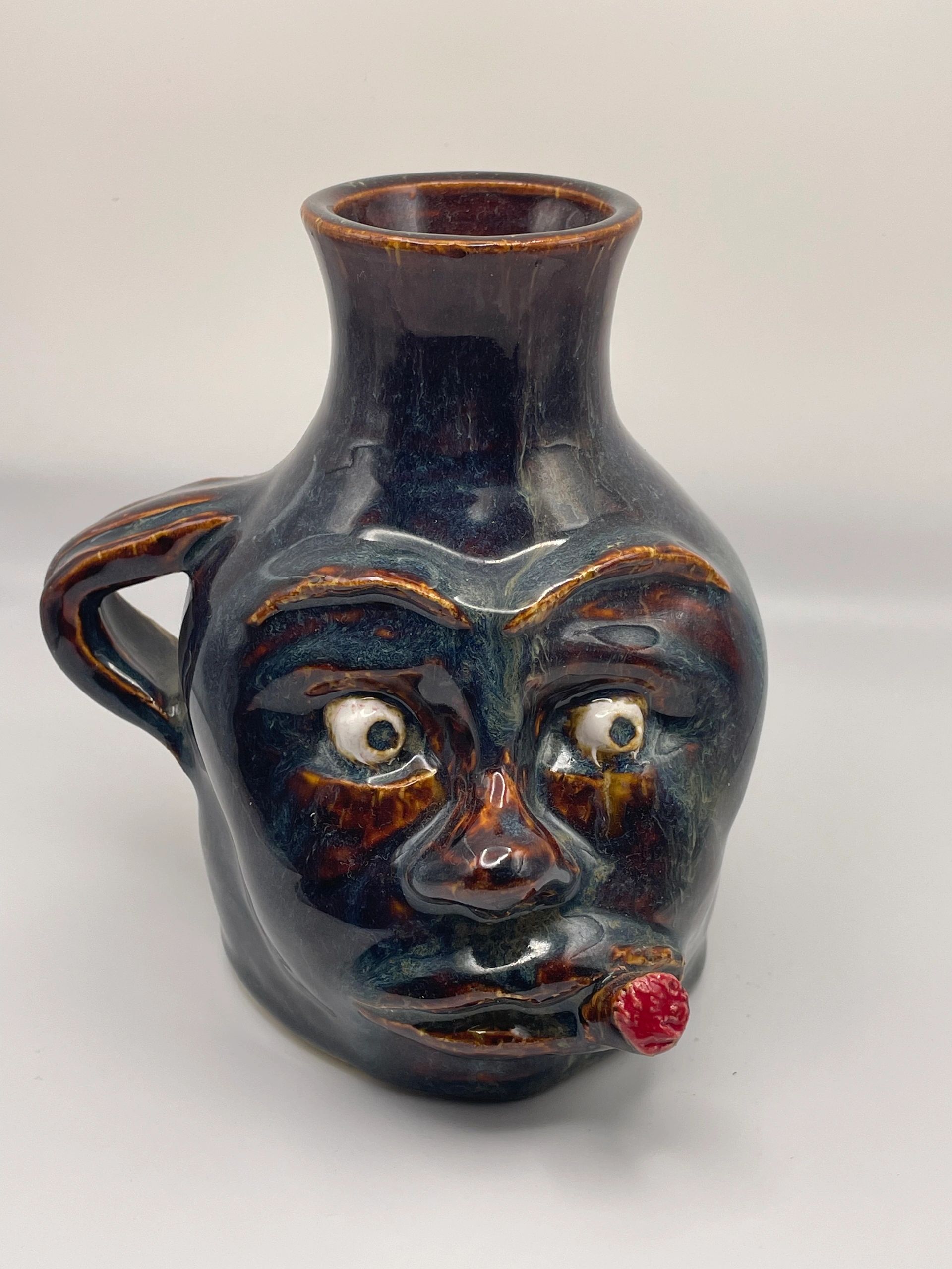 Ceramic mug shaped like a man's face with a cigar.