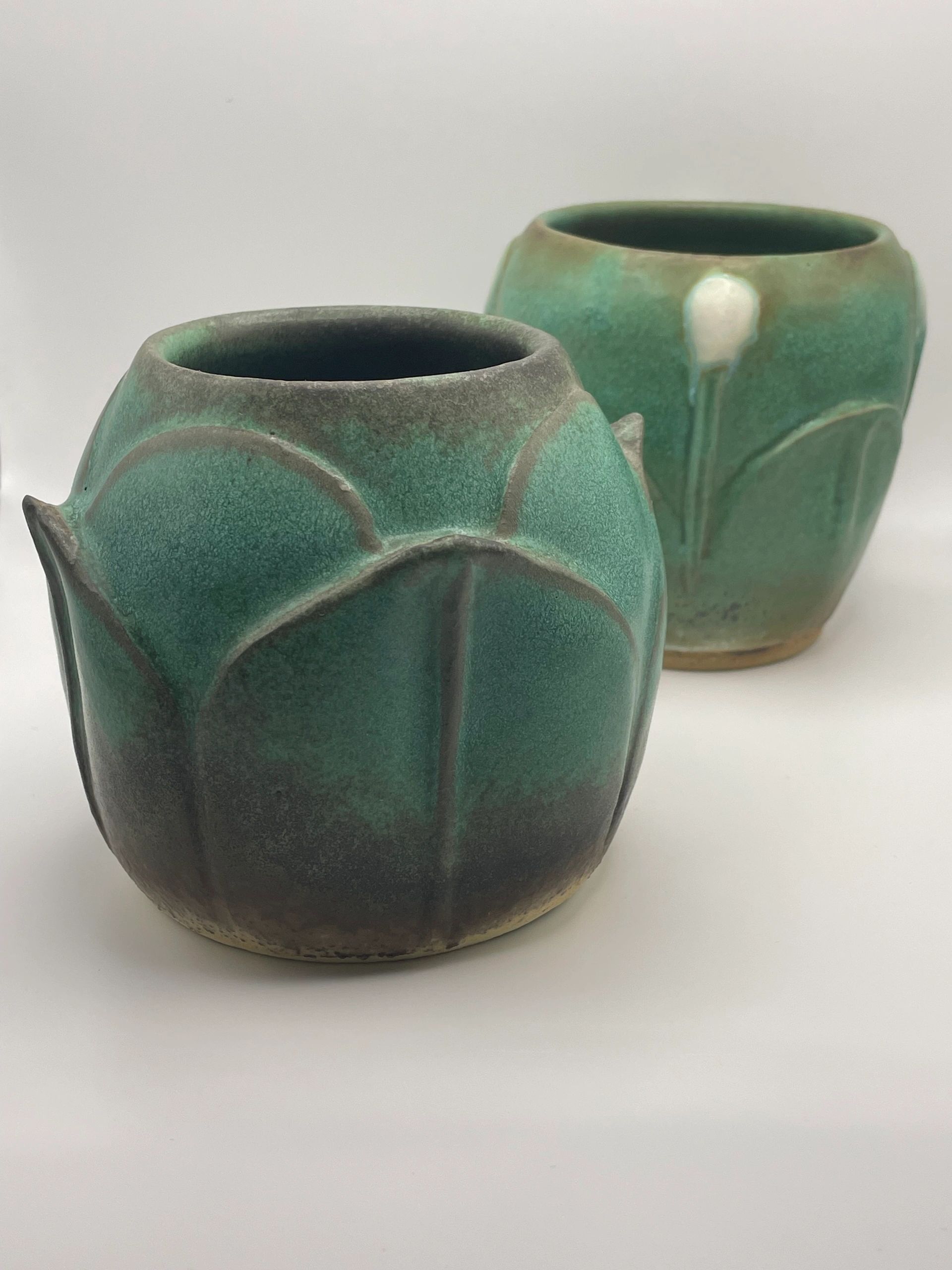 Two green ceramic vases with textured patterns.