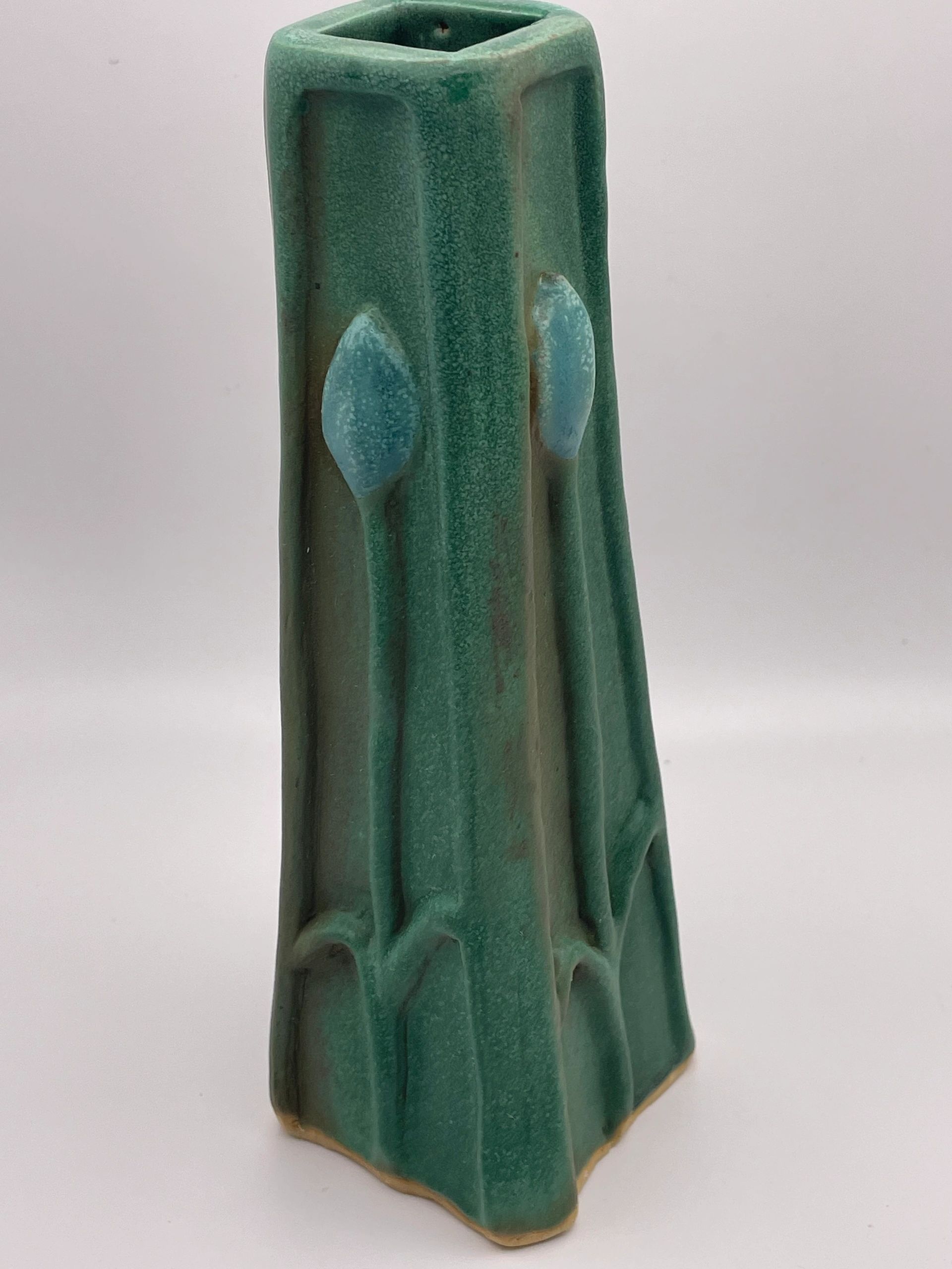 Green ceramic vase with leaf design.