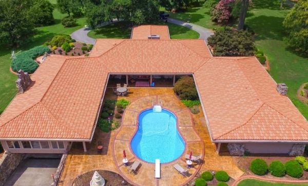 A house with a swimming pool and red roof tiles.