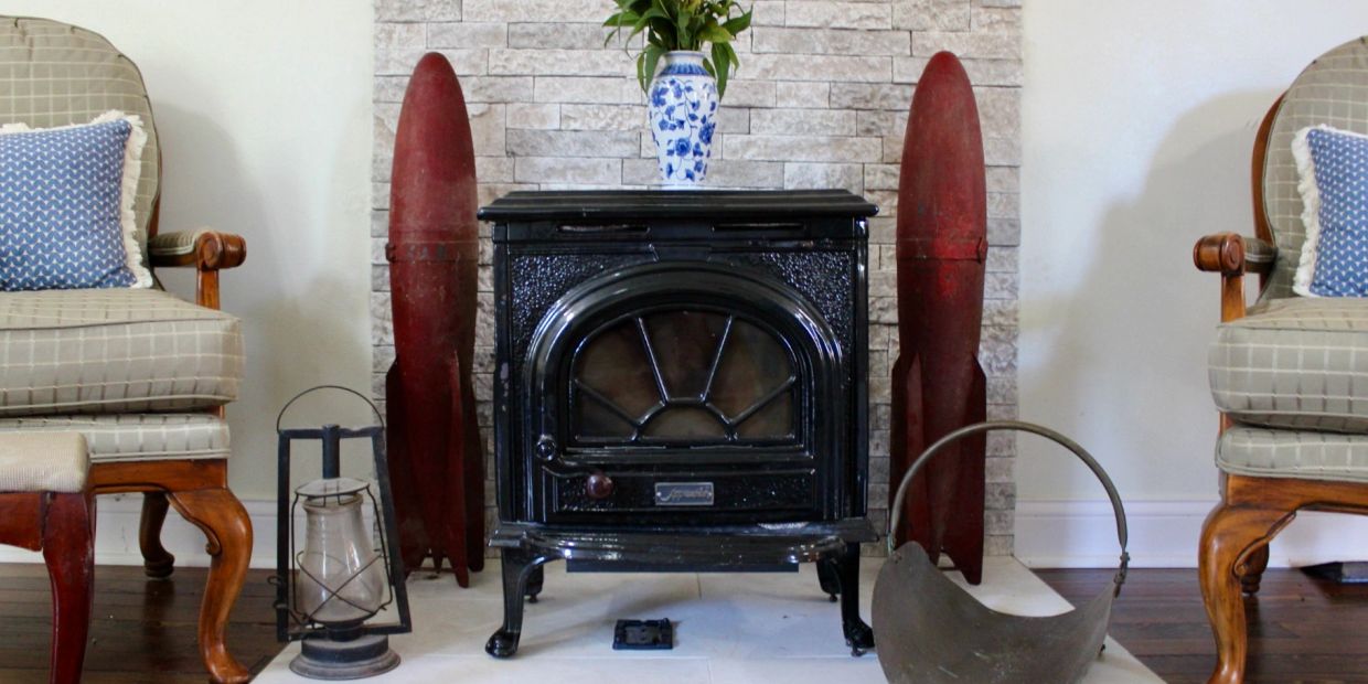 A cozy fireplace setup with armchairs and decorative rockets.