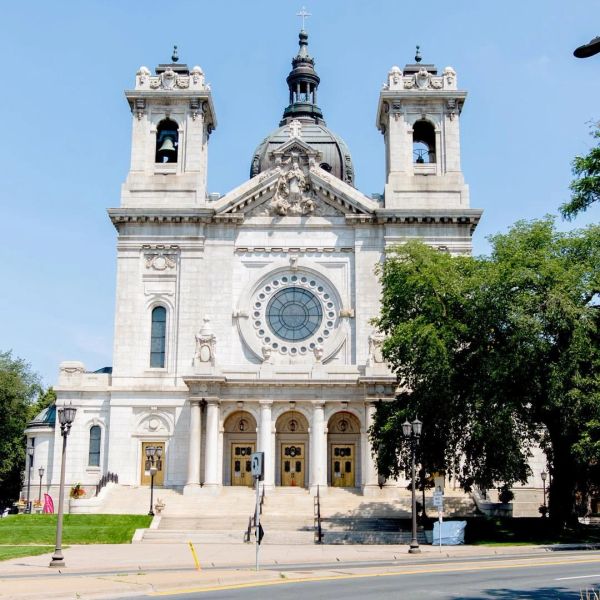 Front view of a historic cathedral with twin towers and a large circular window.