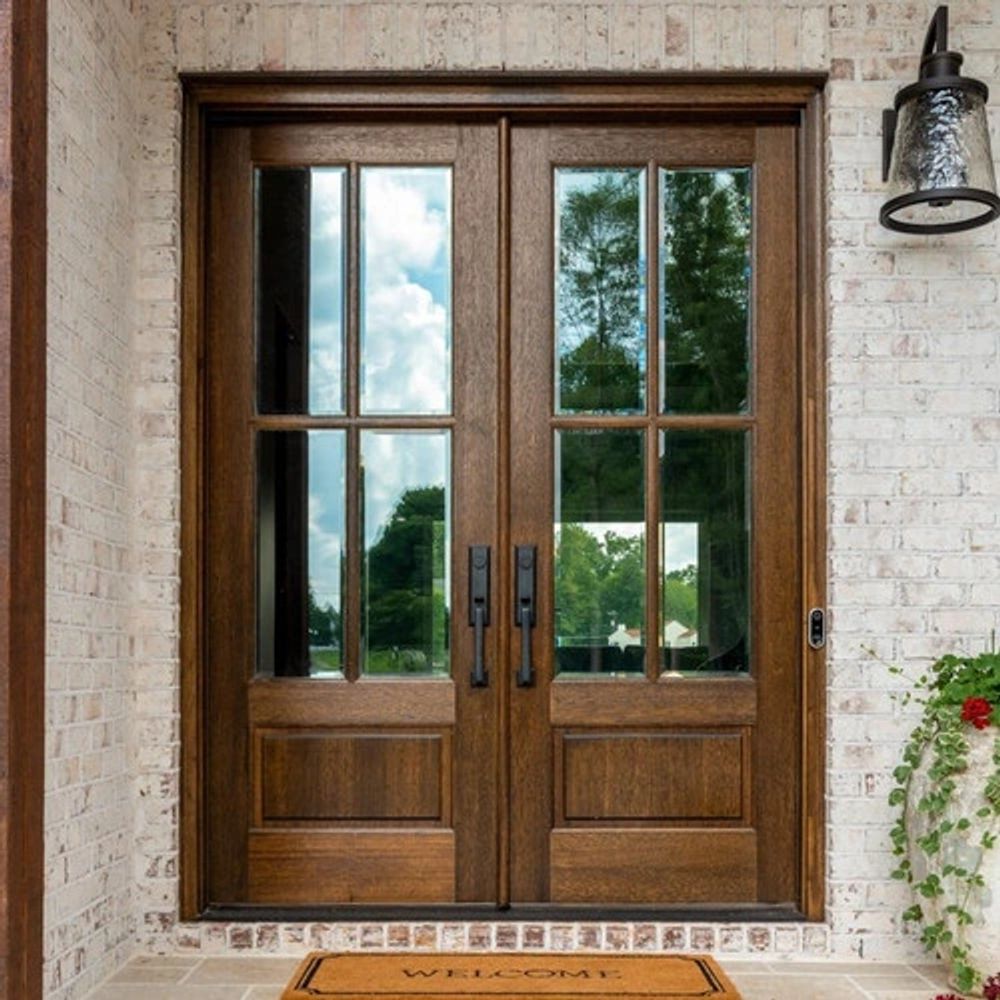 Elegant wooden double front doors with glass panels and black handles.