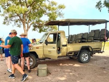 A safari vehicle with passengers preparing to board.
