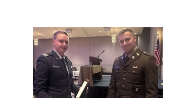 Two men in military uniforms posing indoors.