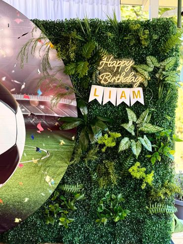 Green leafy birthday backdrop with soccer theme for Liam.