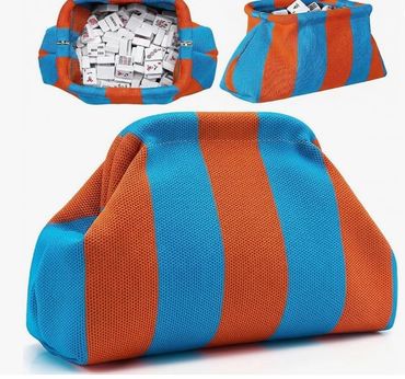Blue and orange striped fabric pouch filled with dominoes.