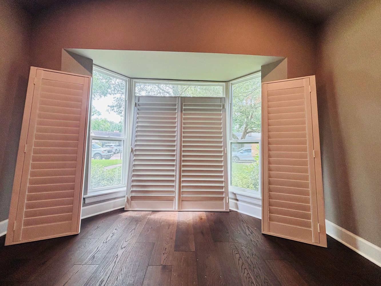 Custom plantation shutters fitted to a bay window in the Memorial neighborhood of Houston, TX
