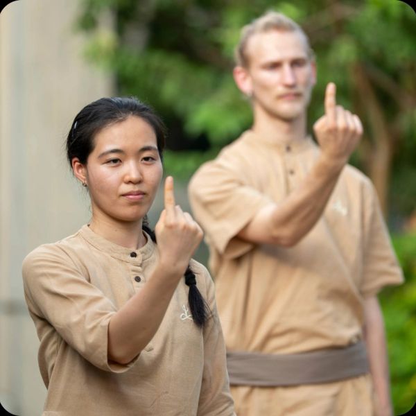 Two people showing their middle fingers in a calm outdoor setting.