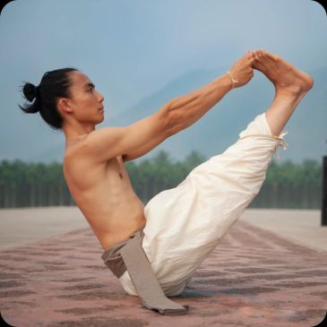 Man practicing yoga outdoors in a boat pose.