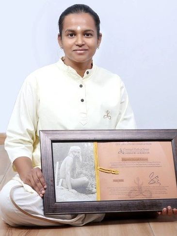 A woman in white holds a framed certificate with a photo and text.