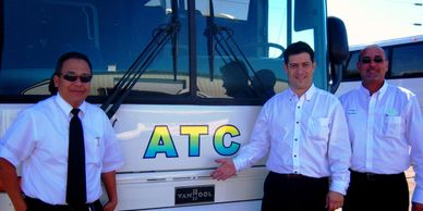 Avalos Transportation Company Inc Employees smiling with a shiny clean white ATC Coach Bus behind
