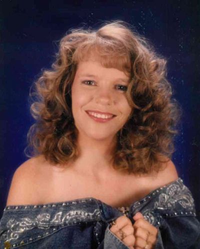 Young woman with curly hair smiling in a portrait.