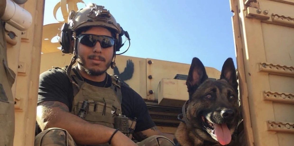 Soldier in tactical gear with a military dog.