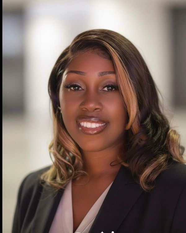 Professional woman with styled hair and a confident smile.