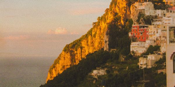 Veduta costiera al tramonto con case su scogliere.