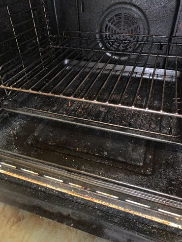 Dirty oven interior with food residue and grease stains.