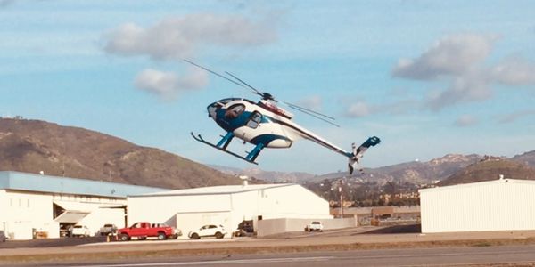 Helicopter in flight near industrial buildings