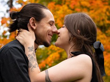 Couple sharing an intimate moment outdoors in autumn.