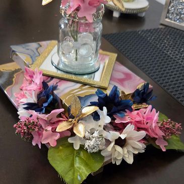 Decorative artificial flower arrangement with pink, blue, and white flowers.