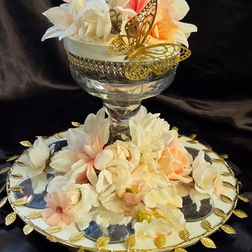 Elegant floral arrangement with golden butterfly and leaf accents.