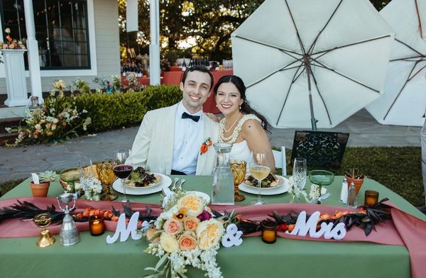 Newlywed couple smiling at their wedding reception.