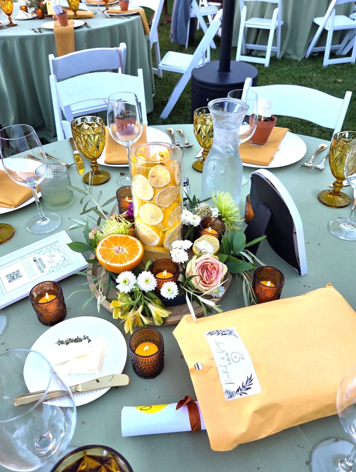 Elegant outdoor table setting with citrus centerpiece and candles.