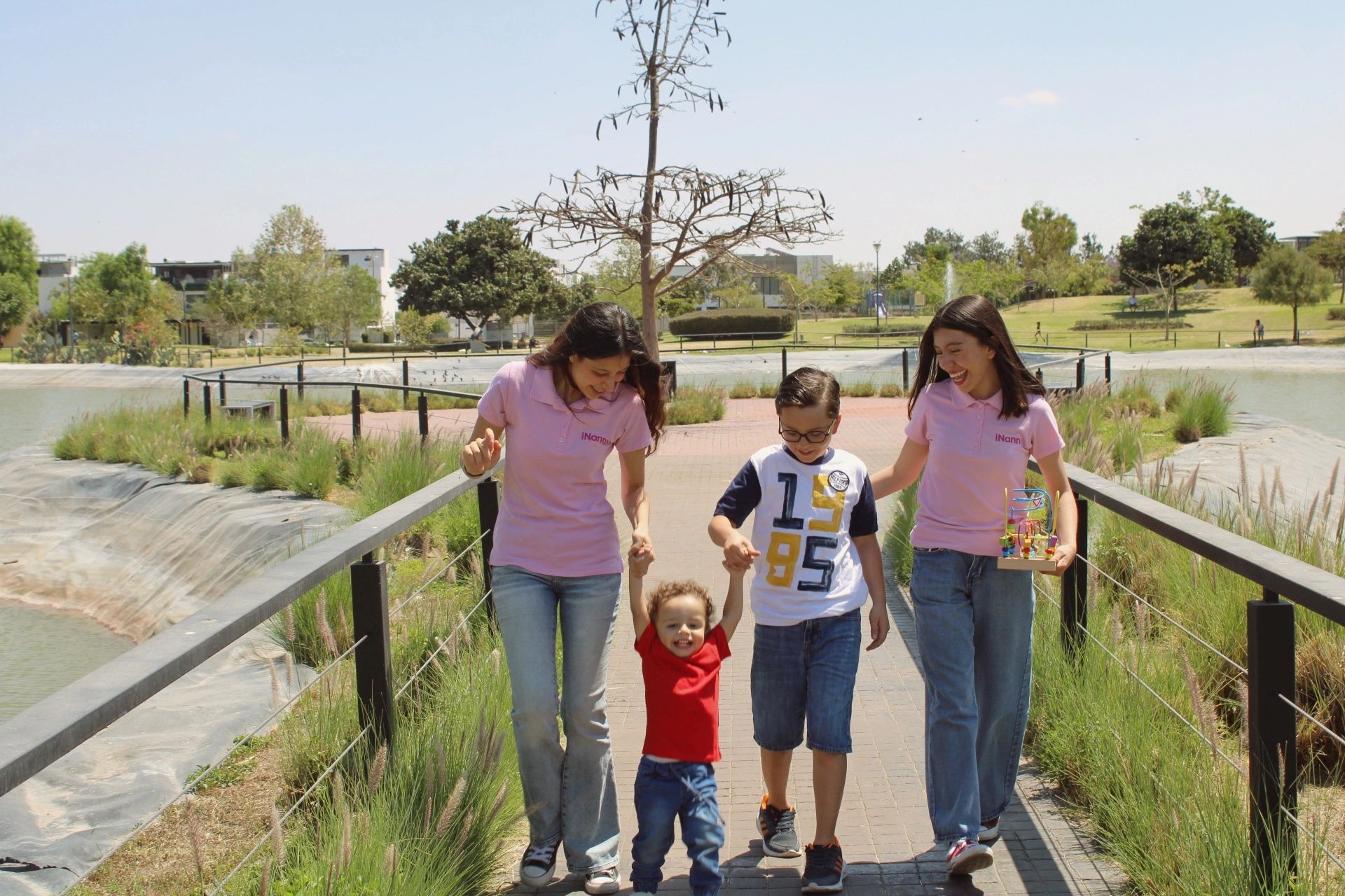 Niñeras de iNanny caminando felizmente con los niños.