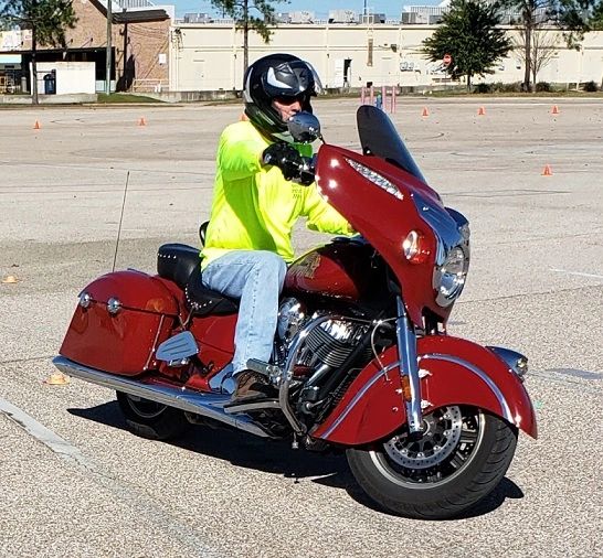 A rider in a hi-visibility jacket on a red motorcycle