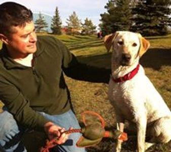 Man holding toy for a yellow lab