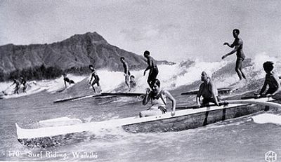 Vintage photo of surfers riding waves in Waikiki.