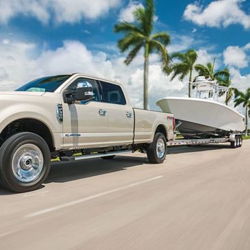 Center console boat on trailer being pulled by pickup truck