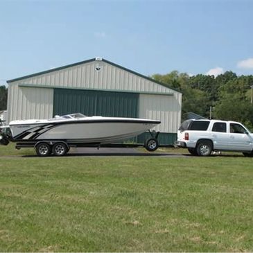 Boat on trailer in front of warehouse