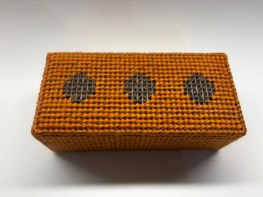 Vintage orange woven rectangular box with three gray circular patterns.